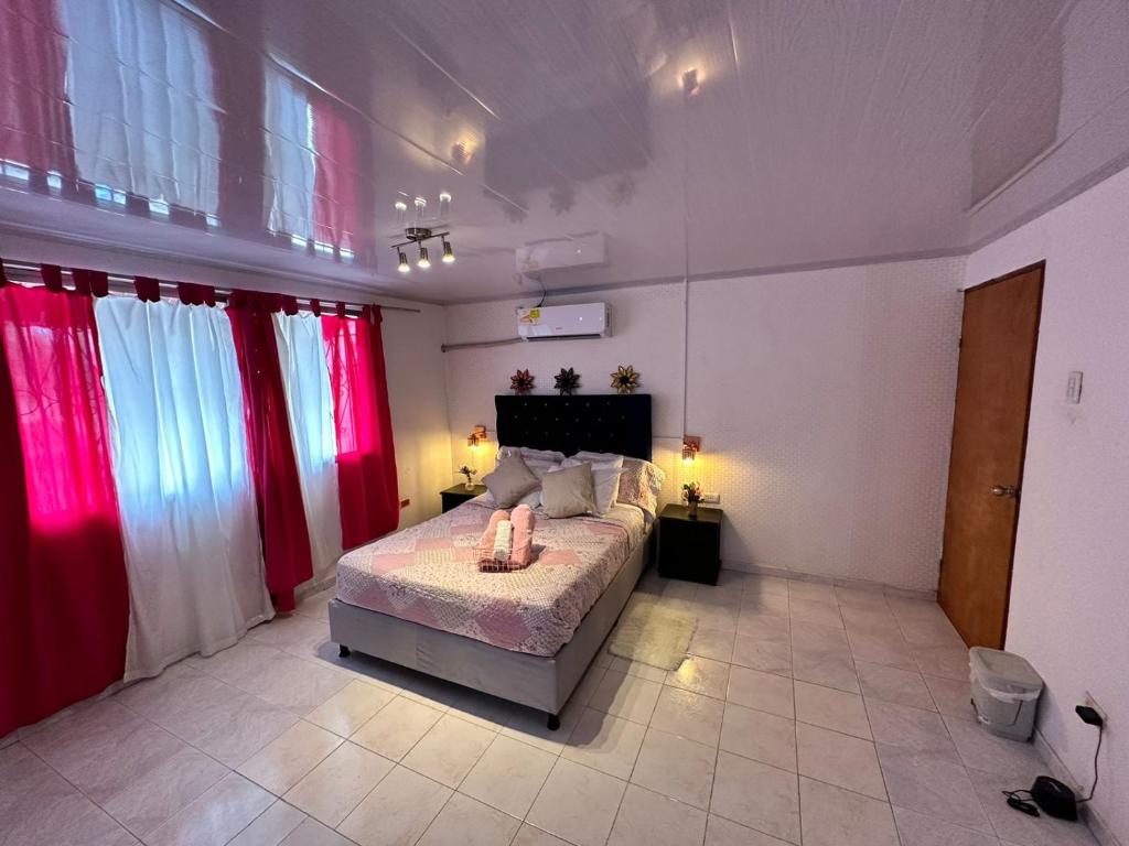 a bedroom with a bed with red and white curtains at H B SULTAN SUITE in Cartagena de Indias