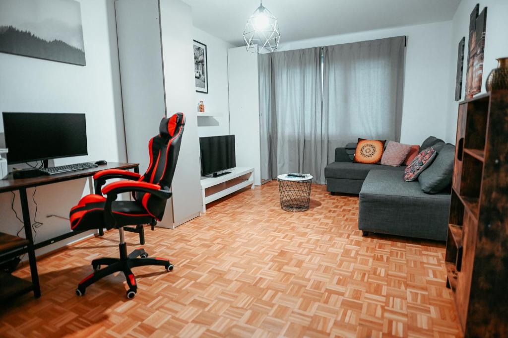 ein Wohnzimmer mit einem Schreibtisch und einem Stuhl in der Unterkunft Vienna Schloss Schönbrunn 15 Apartment in Wien