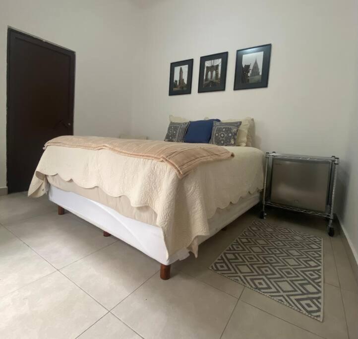 una camera con un letto e due quadri appesi al muro di Linda Habitación en el Centro a Querétaro