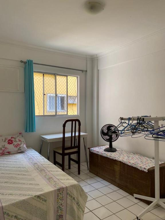 Schlafzimmer mit einem Bett, einem Schreibtisch und einem Stuhl in der Unterkunft Hospedagem para temporada in Recife