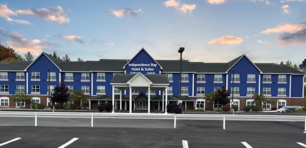 a large blue building with a parking lot in front of it at Independence Stay Hotel & Suites in Marinette