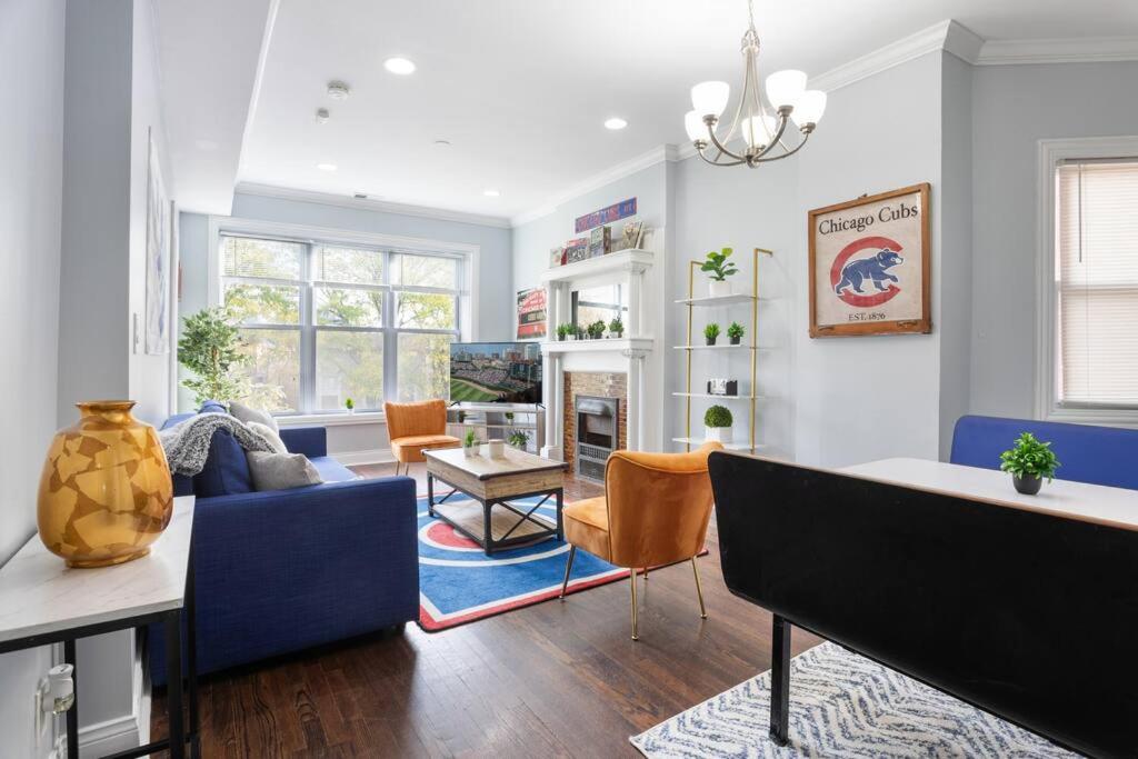 a living room with a blue couch and chairs at Game Day Getaway - 3BR in Vibrant Wrigleyville in Chicago