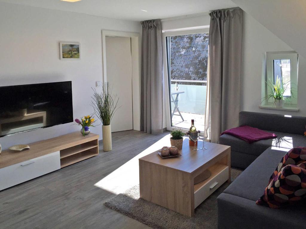 a living room with a couch and a coffee table at Ferienwohnung Le Papillon in Kröslin