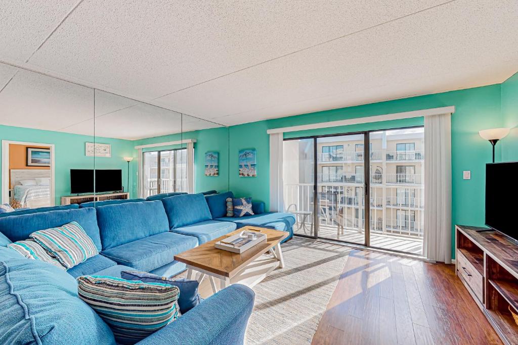 a living room with a blue couch and a tv at Wight Bay North #439 in Ocean City