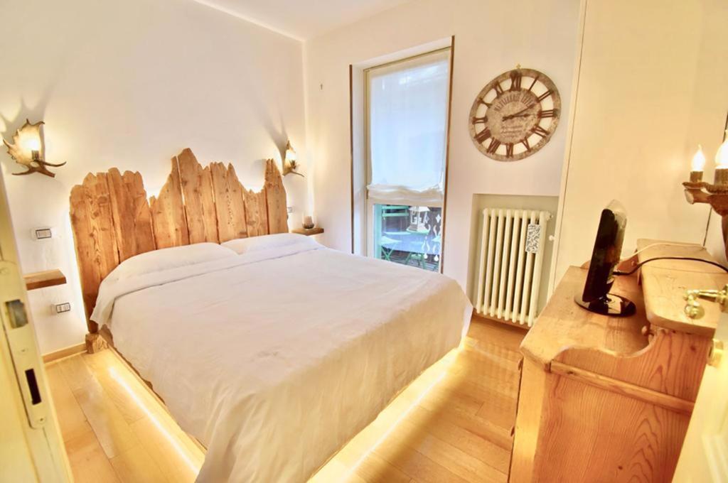 um quarto com uma cama grande e uma janela grande em Sweet Campiglio em Madonna di Campiglio