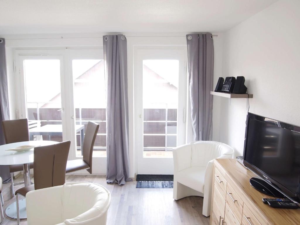 een woonkamer met een televisie en een tafel en stoelen bij Ferienwohnung Schimmer 27 in Braunlage