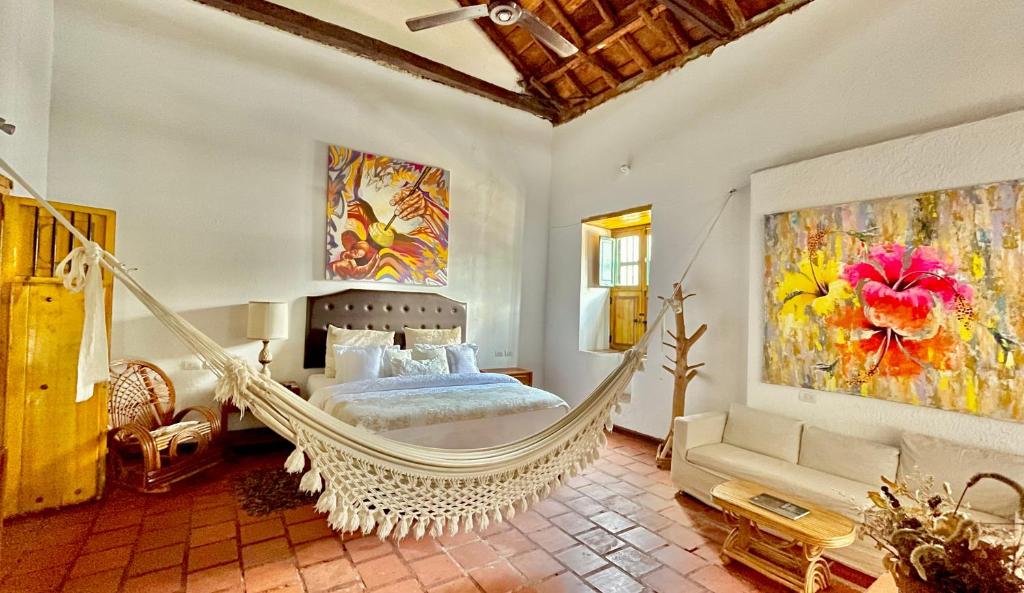 a bedroom with a swinging bed and a painting at Hotel Boutique Casa de Los Santos Reyes Valledupar in Valledupar