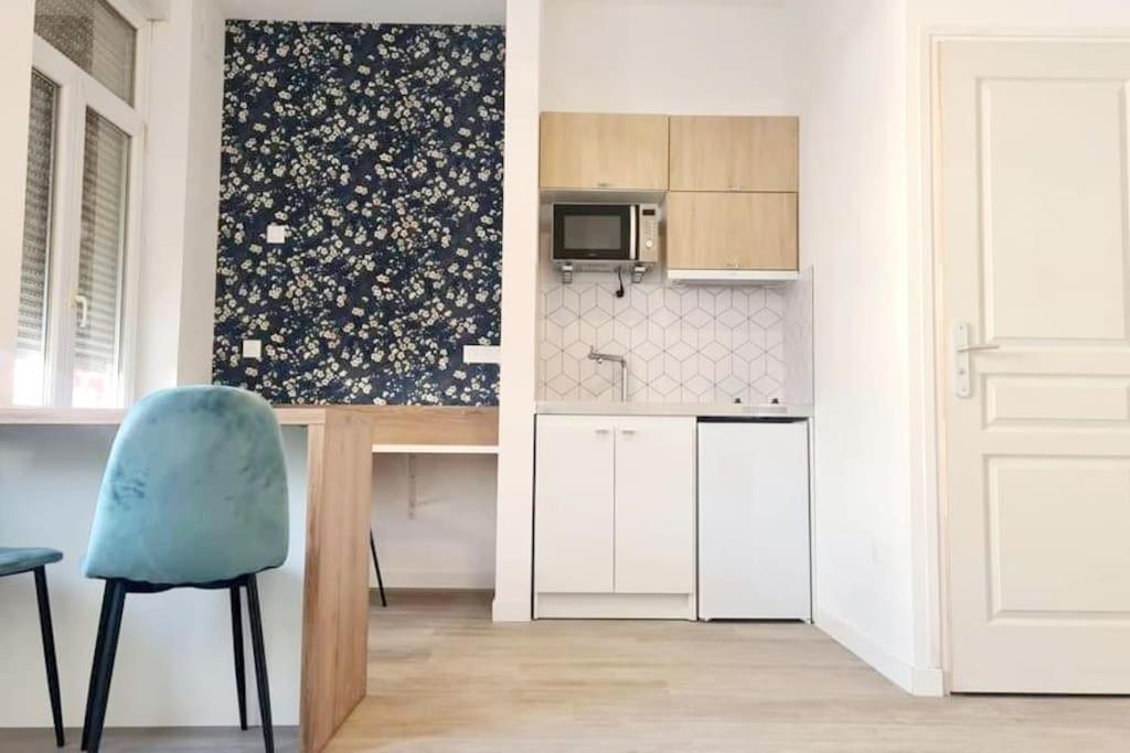 cocina con mesa y silla azul en Studio entièrement rénové proche gare, en Cambrai