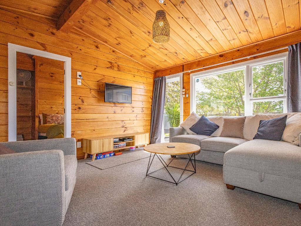 a living room with two couches and a table at Kaka Retreat - Taupo Holiday Home in Taupo
