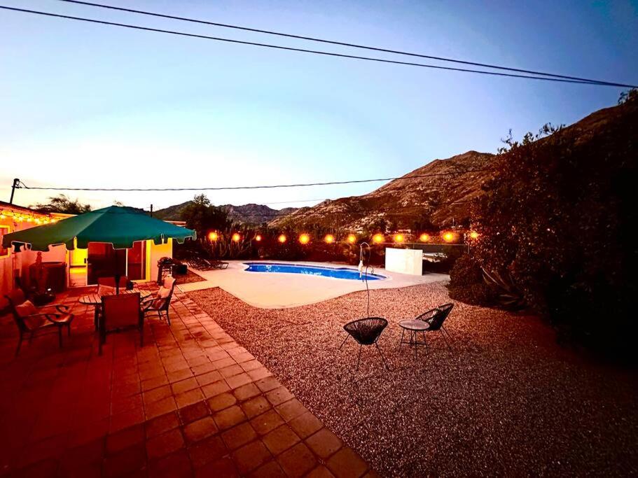 un patio con sillas, una sombrilla verde y una piscina en FunFilled Retreat with Pool and Game Room Sleeps 10 plus, en Riverside