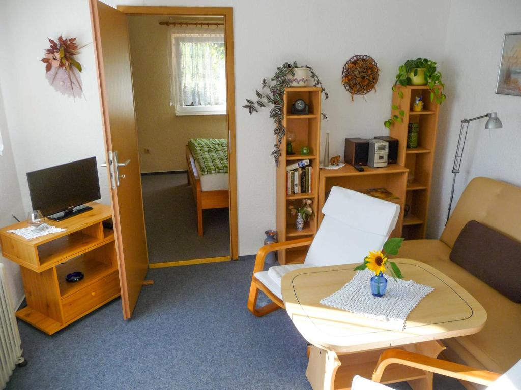 a living room with a couch and a television at Bungalow im Garten in Malchow