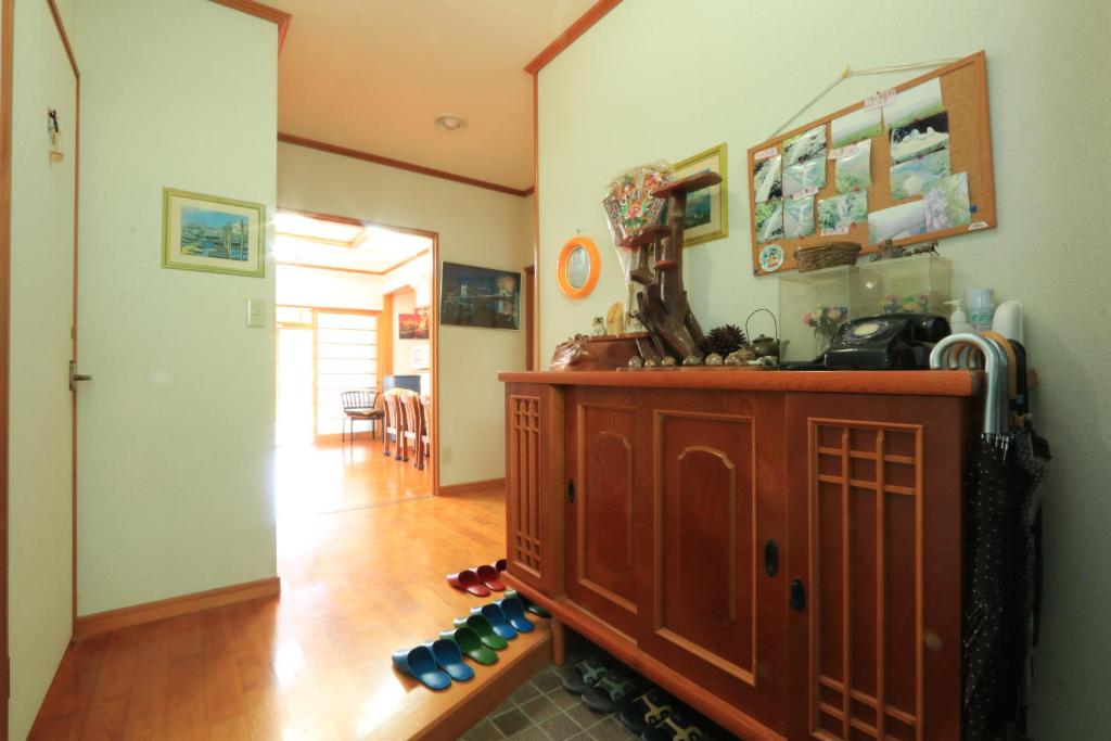 Minshuku Satomachi في ياكوشيما: غرفة معيشة مع خزانة خشبية وممر