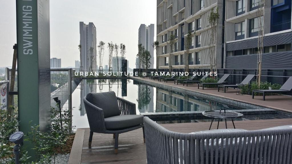 - un balcon avec des chaises et une piscine dans un bâtiment dans l'établissement Tamarind Suites or D'Pulze Residence or Domain NeoCyber, click Room selection for location and pics, à Cyberjaya