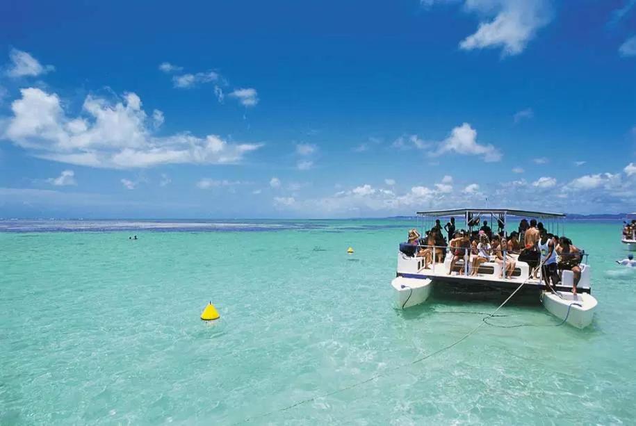 a group of people on a boat in the ocean at Sol do Caribe Suítes in Maragogi
