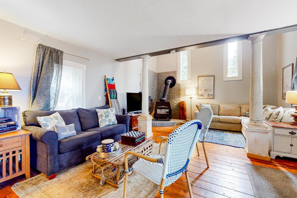 sala de estar con sofá azul y sillas en Maple's Suite, en Quechee