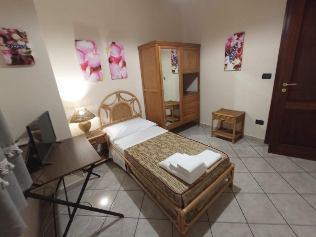 een slaapkamer met een bed, een tafel en een spiegel bij I Fiori di AminA Le Begonie in Pietramelara