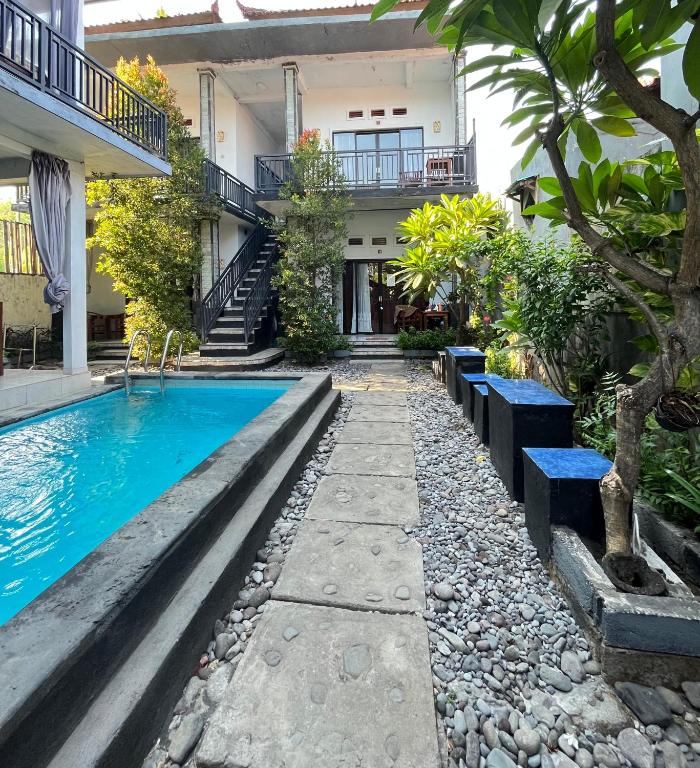 a pool in front of a building with a house at D Jana in Amed