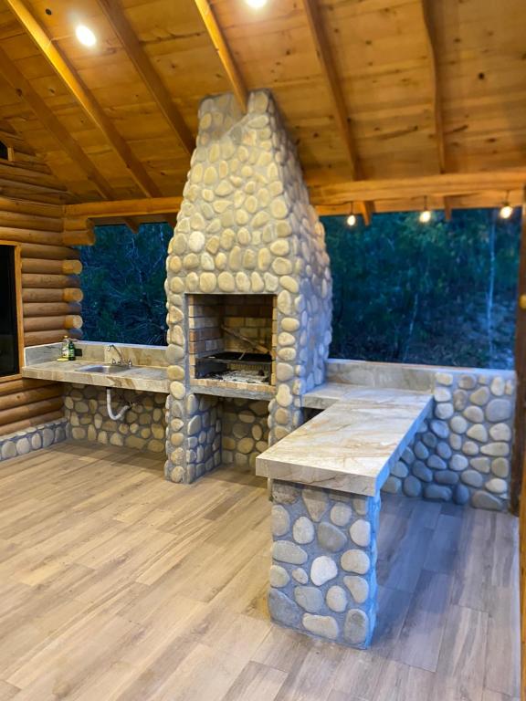 a patio with a stone fireplace in a log cabin at Cabañas Sierra Grande in Santiago