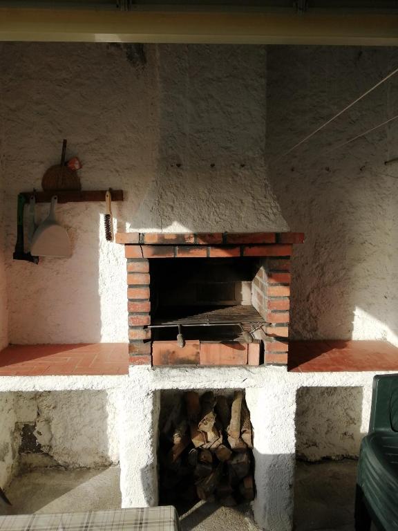 a brick oven with a pile of logs in it at Casa Dos Mosteiros in Mosteiros
