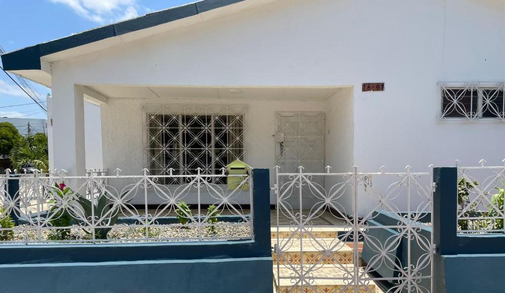 uma casa branca com uma cerca à frente. em La Casa de Tía Ana em Ríohacha