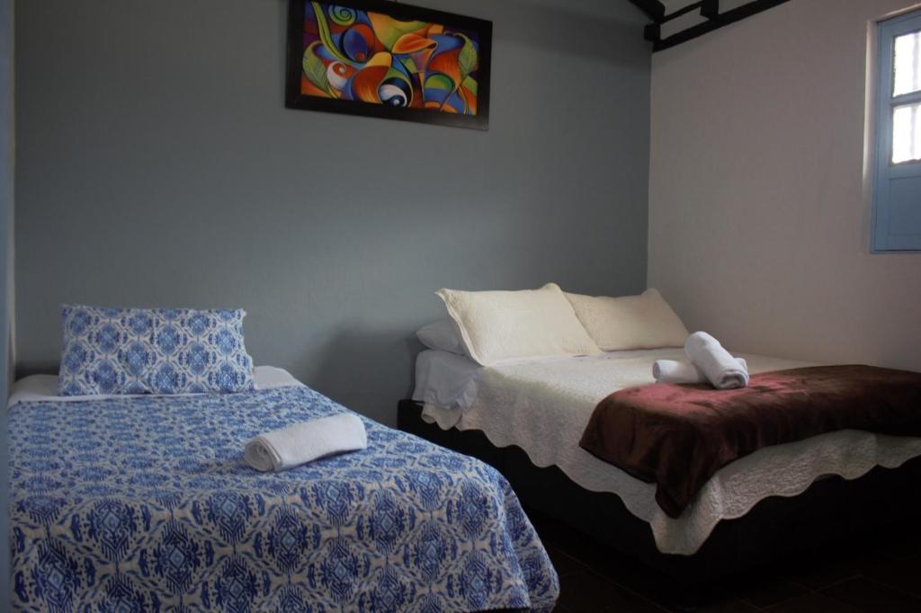- une chambre avec 2 lits et des serviettes dans l'établissement Casa Noche Azul alojamiento turístico en Villa de Leiva, à Villa de Leyva