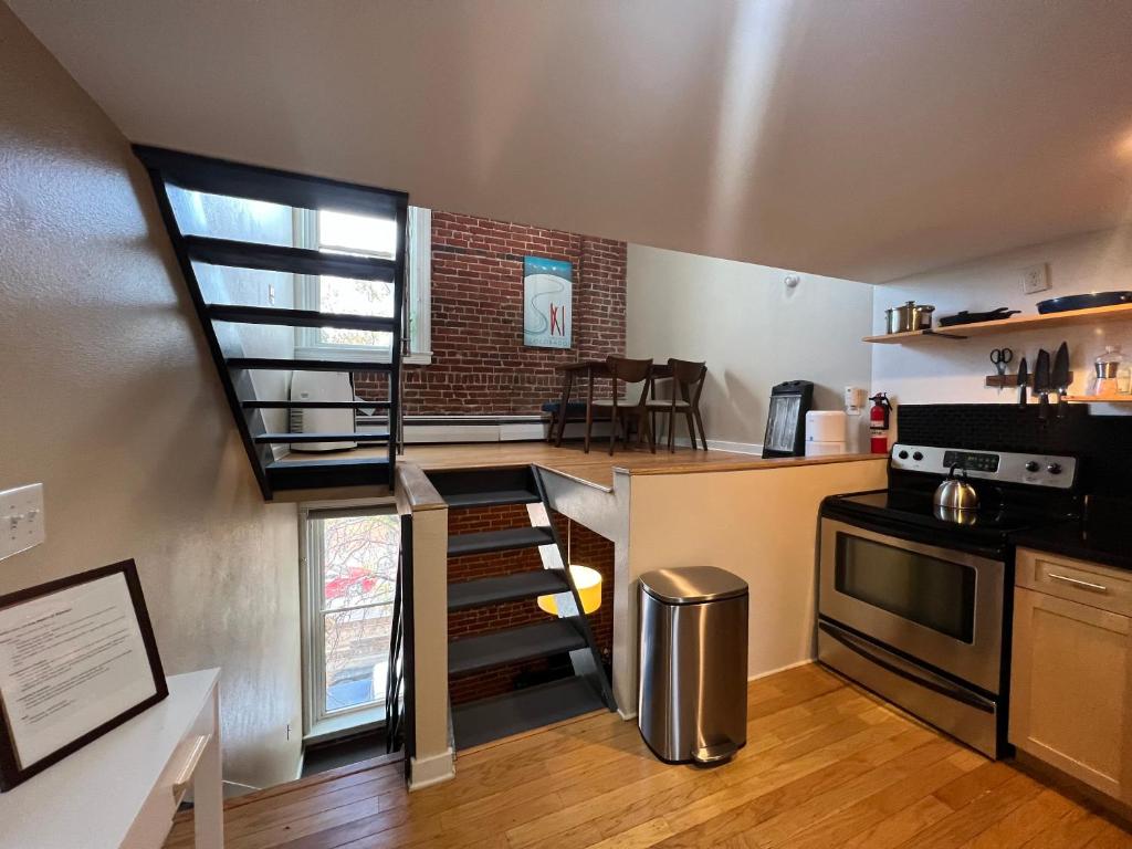 a kitchen with a spiral staircase leading to a loft at Affordable & Chic RiNo/LoDo/Dtown Loft- Walkable in Denver