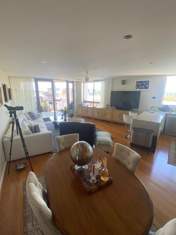 a living room with a wooden table and a couch at Guesthouse, read about the host before booking please in Wollongong
