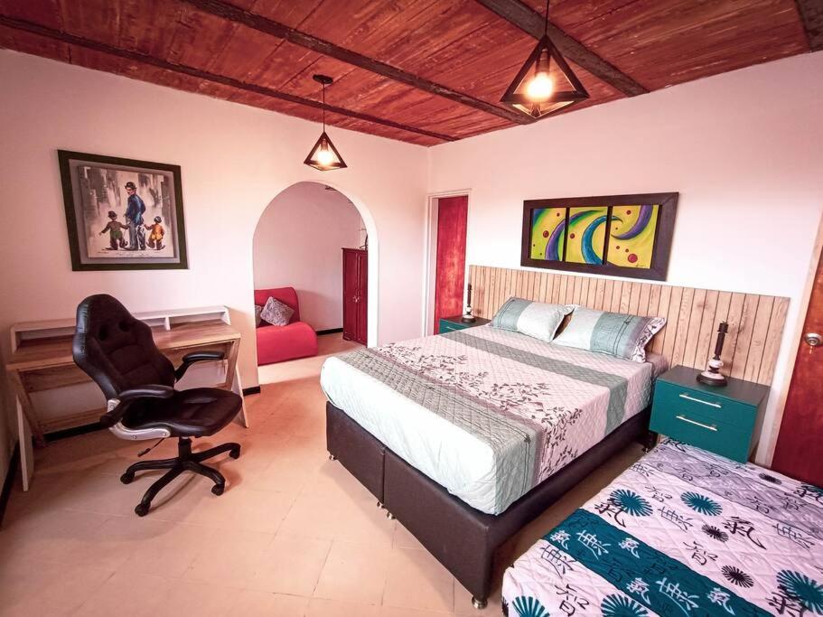 麥德林的住宿－Amplio duplex con terraza privada.，一间卧室配有一张床、一张桌子和一把椅子