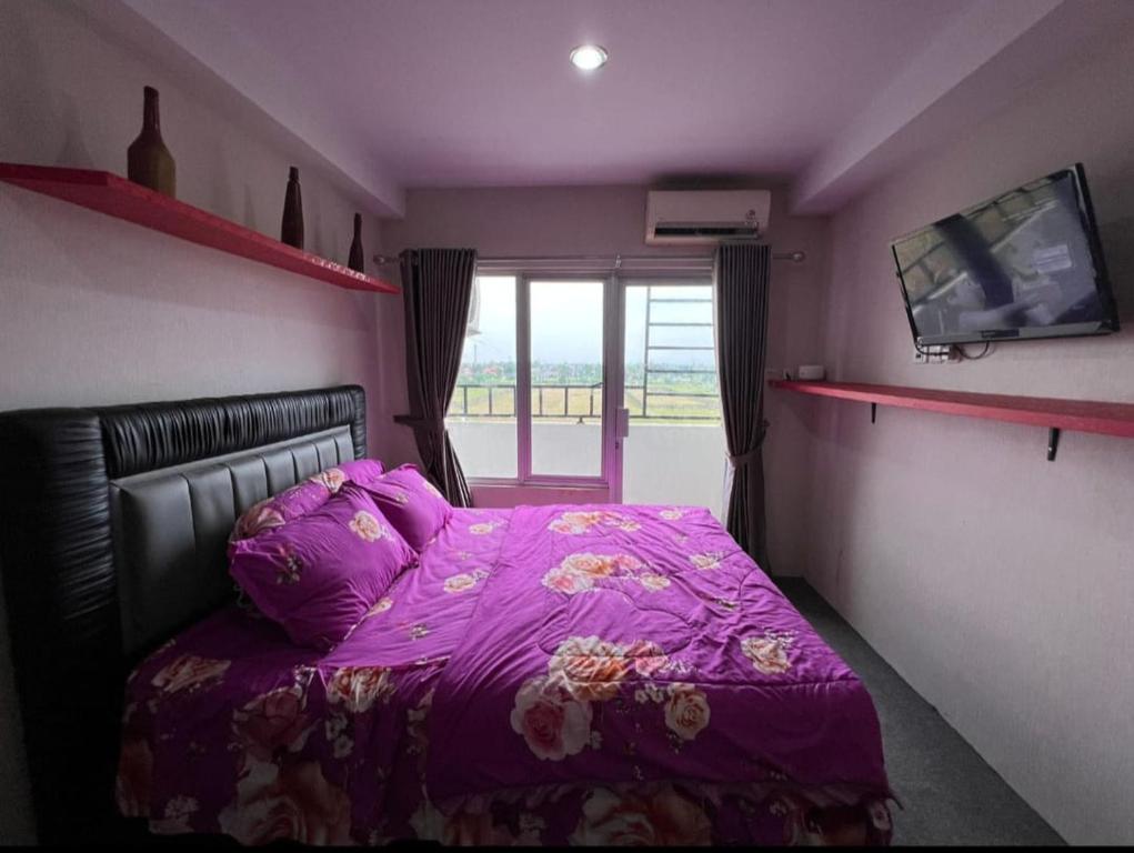 a purple bedroom with a bed with a purple blanket at Niar P in Sunggal