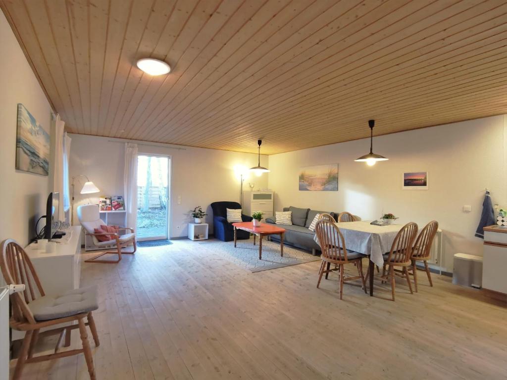ein Wohnzimmer mit einem Tisch, Stühlen und einem Sofa in der Unterkunft Ferienhaus Eggert in Lindewitt