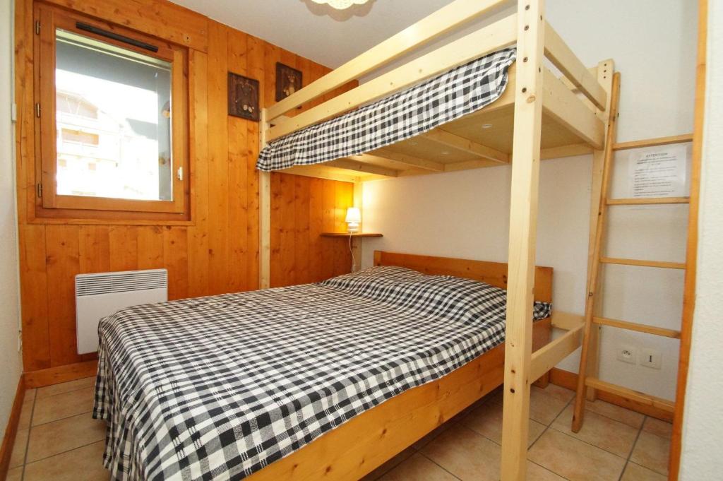 萊德薩阿爾卑斯的住宿－Résidence Chalet d'Or by Leavetown Vacations，一间卧室配有一张双层床和梯子
