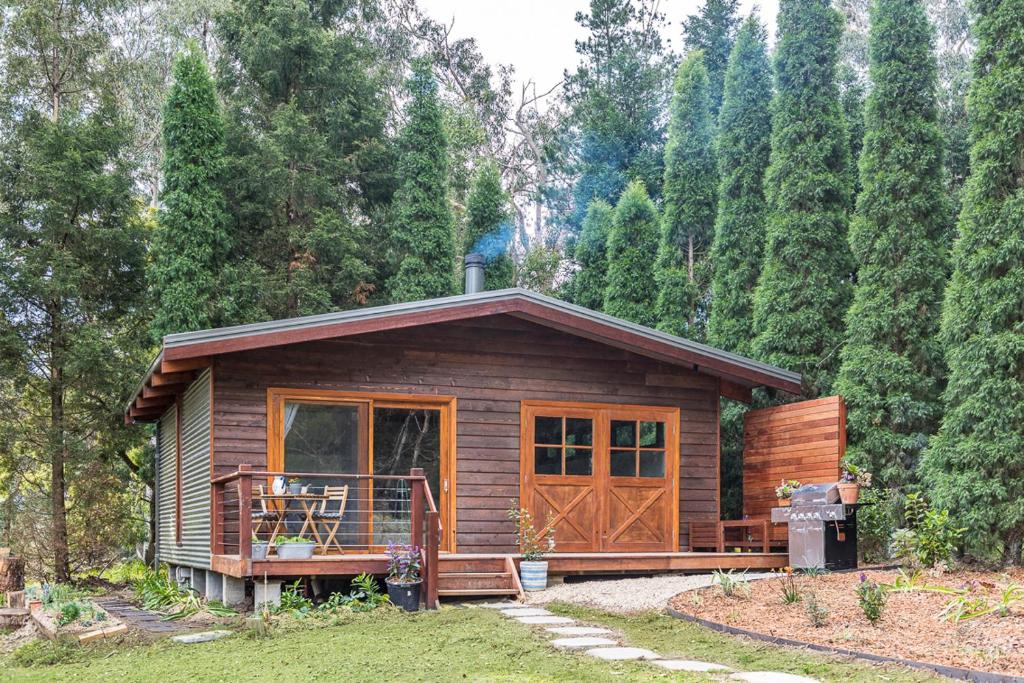 a small cabin in the woods with a porch at Crabapple Cabin in Bowral