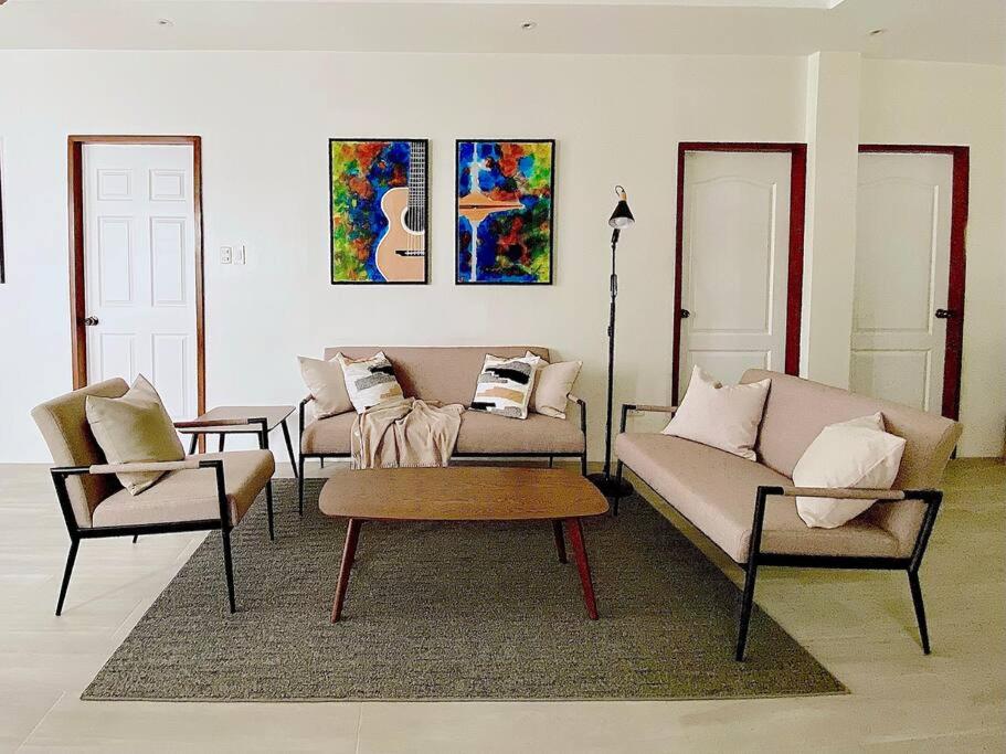 a living room with two couches and a coffee table at Brand New Home in Cebu City with 3 Large Bedrooms! in Cebu City