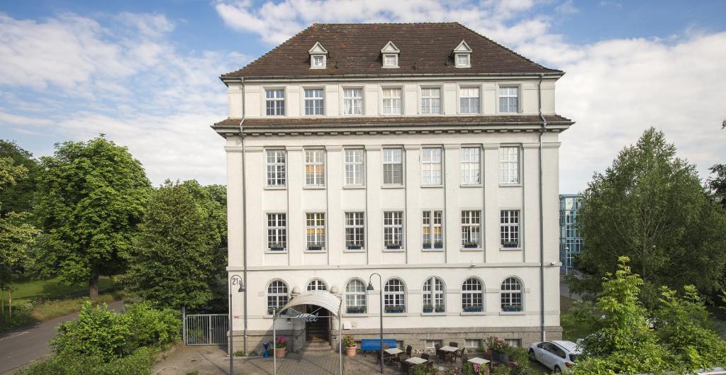 a large white building with a tower on top of it at Apartment Hotel Konstanz in Konstanz