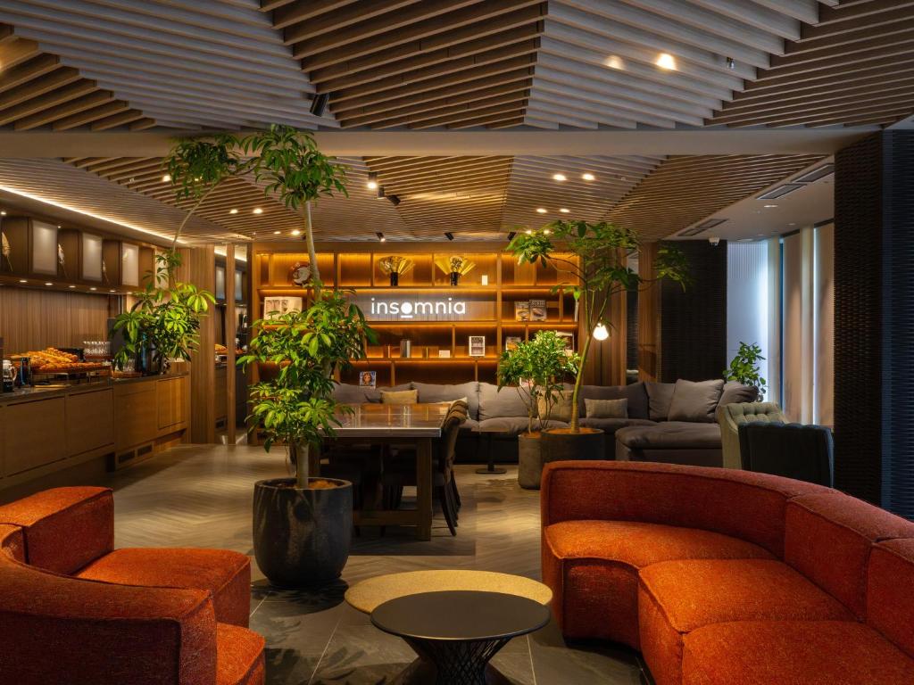 a lobby with a table and chairs and plants at insomnia KYOTO OIKE in Kyoto