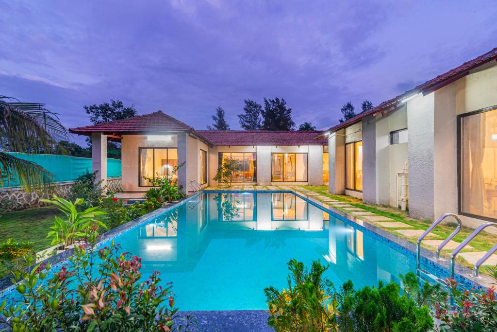 an image of a house with a swimming pool at SaffronStays Mangi Ferra in Karjat
