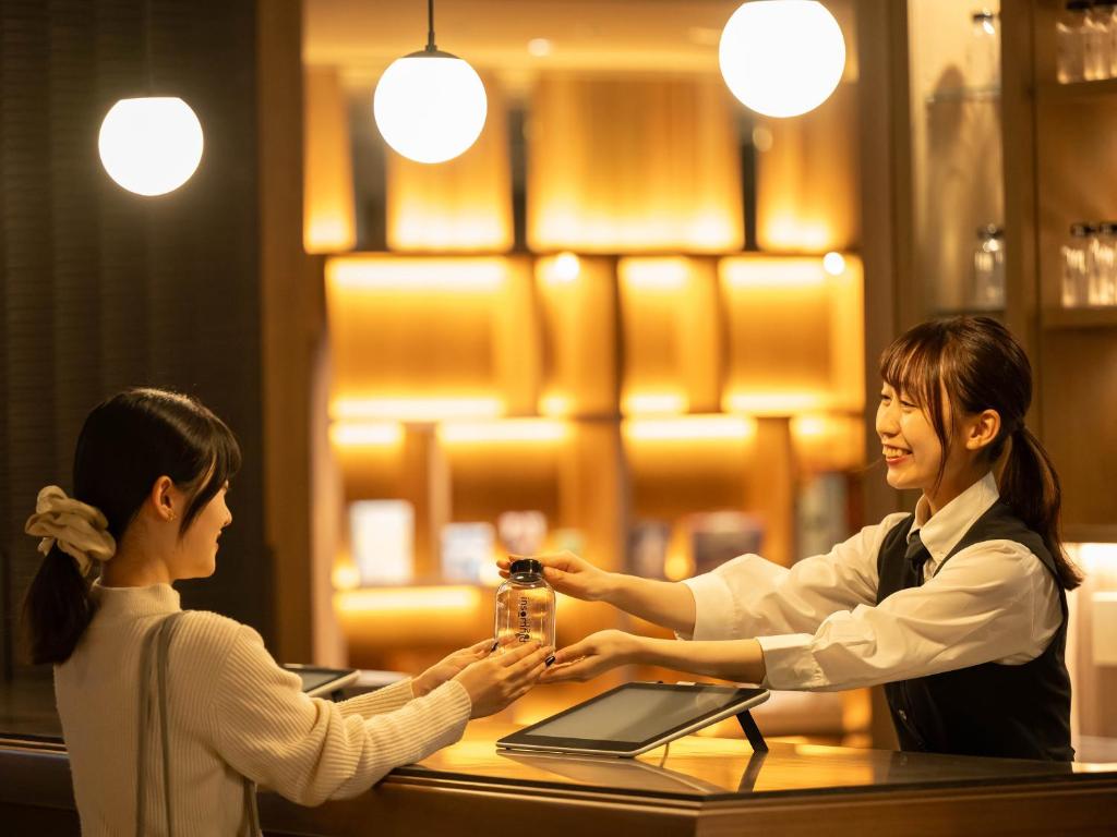 京都市にあるinsomnia KYOTO OIKEの二人の女性がレストランのテーブルで握手
