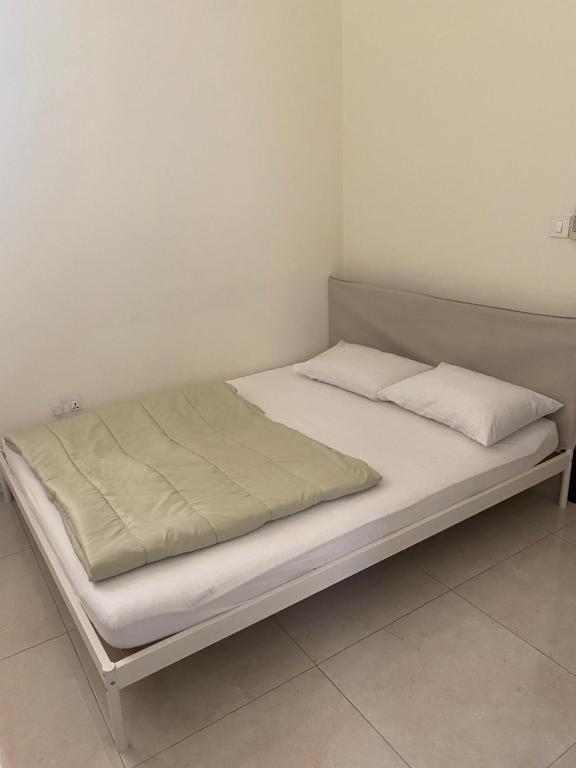 un letto con due cuscini sopra in una stanza di Your Studio Near Airport and all a Abu Dhabi