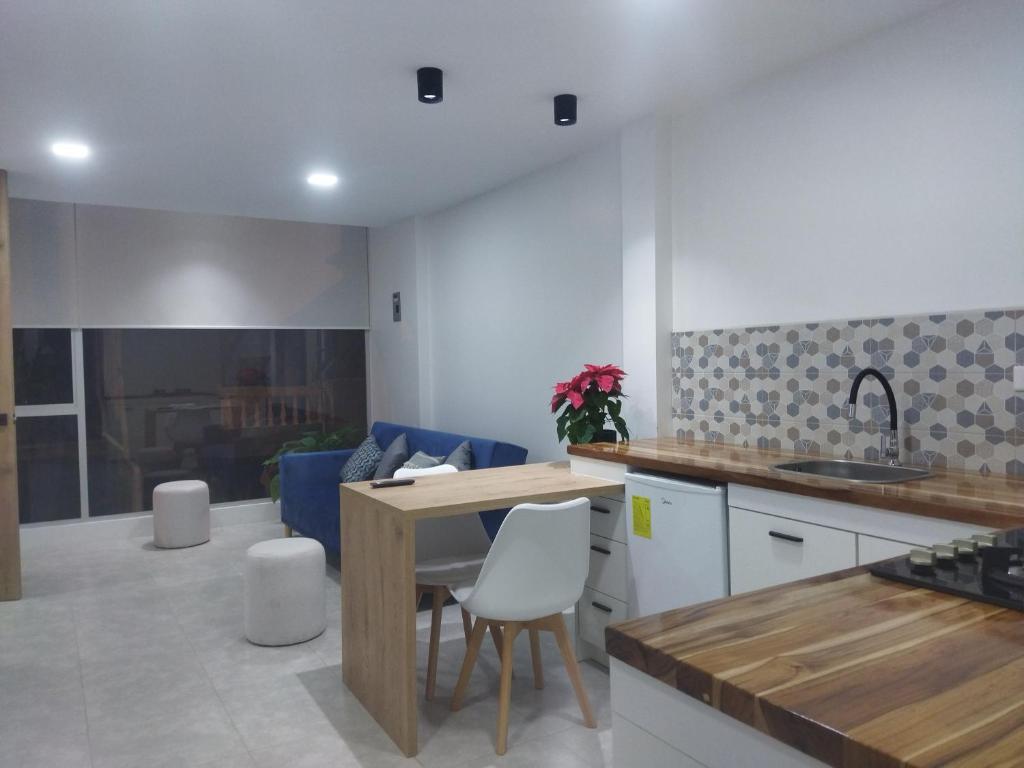 uma cozinha e sala de estar com mesa e cadeiras em ROZA apartaments & suits em Loja