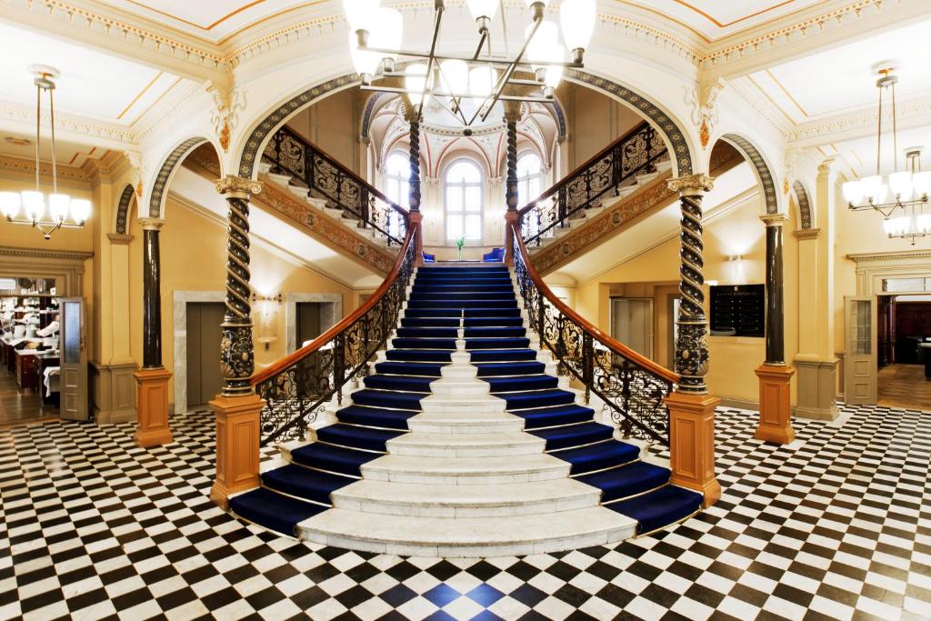 a spiral staircase in a building with a checkered floor at Elite Hotel Knaust in Sundsvall