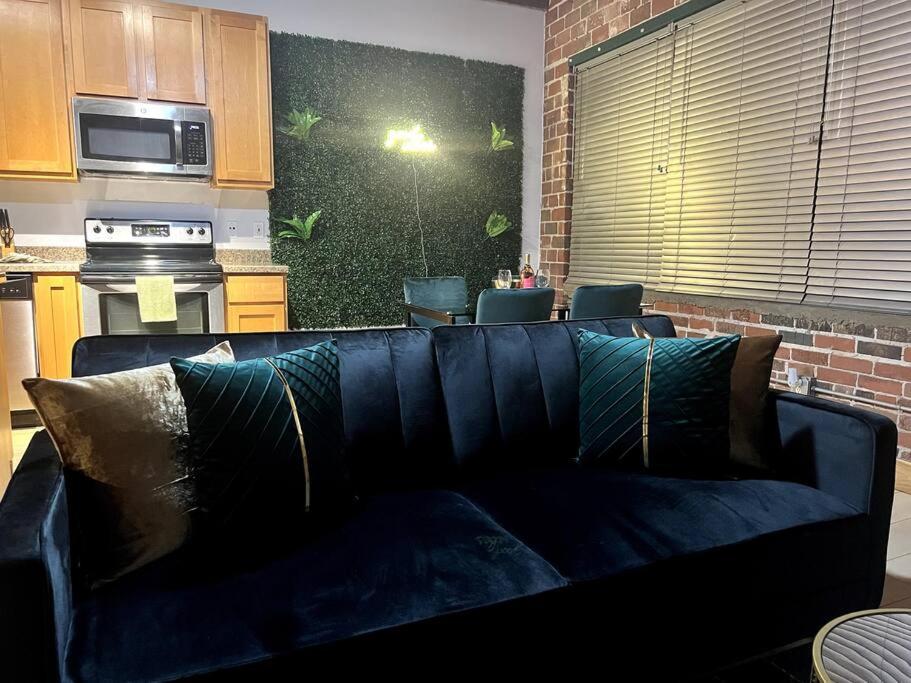 聖路易斯的住宿－Serene Living Downtown STL Loft，客厅设有蓝色沙发,厨房设有