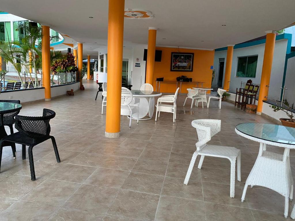 a room with tables and chairs and tables and chairs at Hotel la cascada cristalina in Melgar