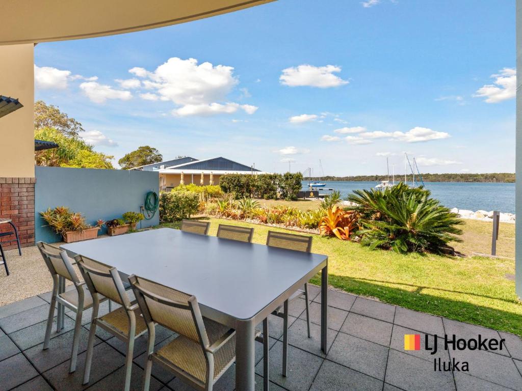 einen Tisch und Stühle auf einer Terrasse mit Blick auf das Wasser in der Unterkunft Riverview Apartments 1 3 Building 1 Unit 3 in Iluka