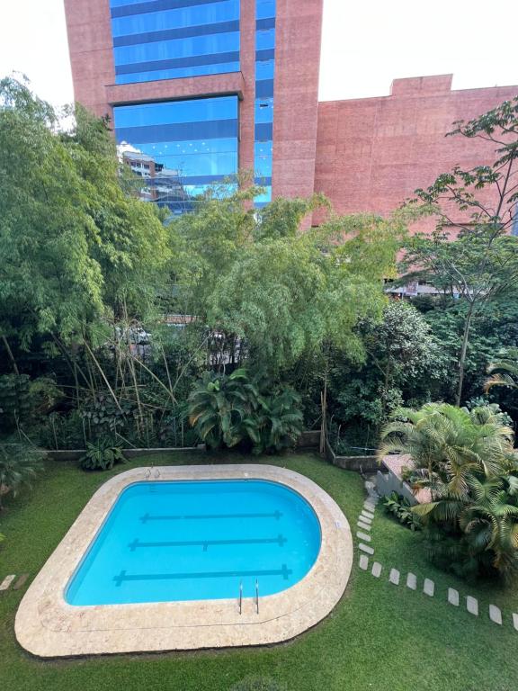 una piscina en un jardín con un edificio en Apartamento hermoso en el mejor barrio Medellín, en Medellín