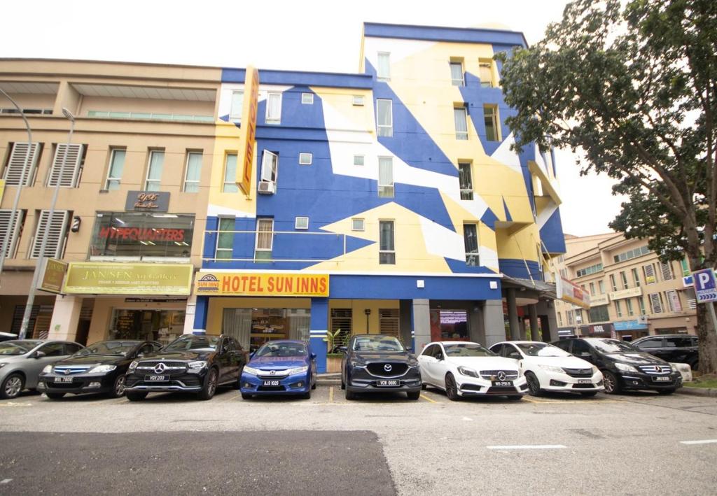 un groupe de voitures garées devant un bâtiment dans l'établissement Sun Inns Hotel Kota Damansara Near Hospital Sungai Buloh, à Kota Damansara