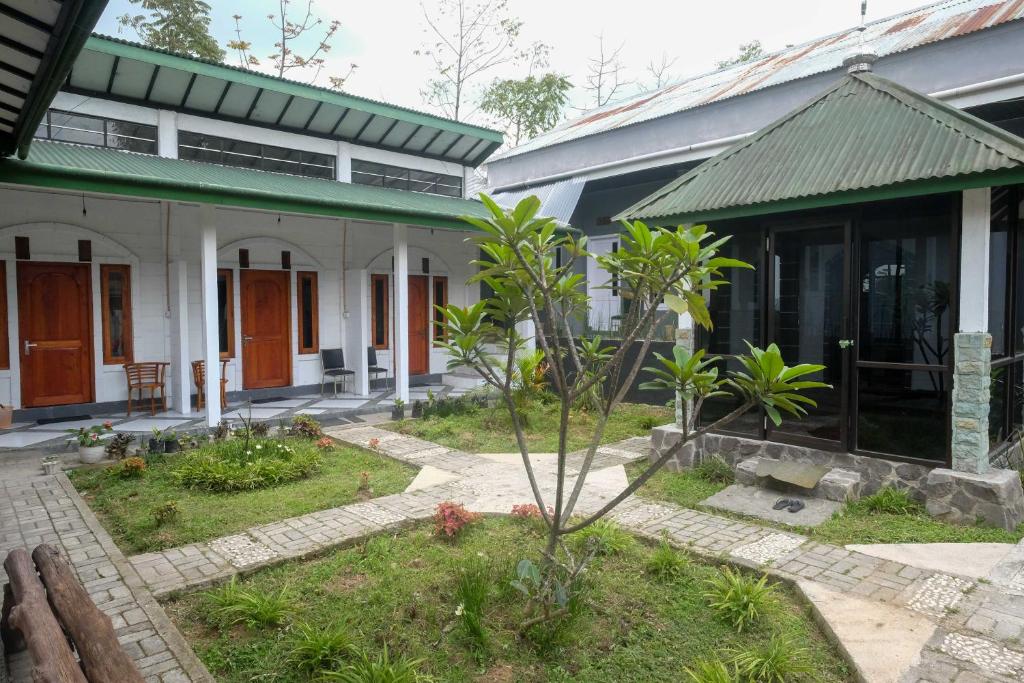 une maison avec un jardin en face dans l'établissement RedDoorz Syariah @ Jalan Dieng Wonosobo 2, à Garung
