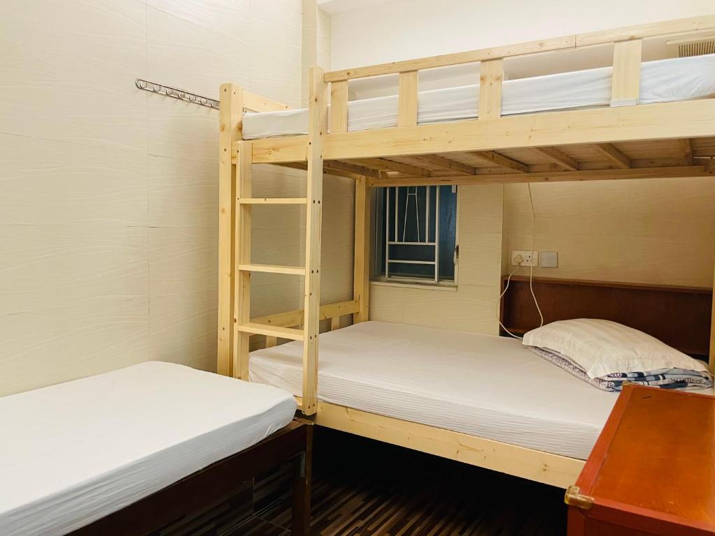 two bunk beds in a small room with a window at Johnson Hostel in Hong Kong