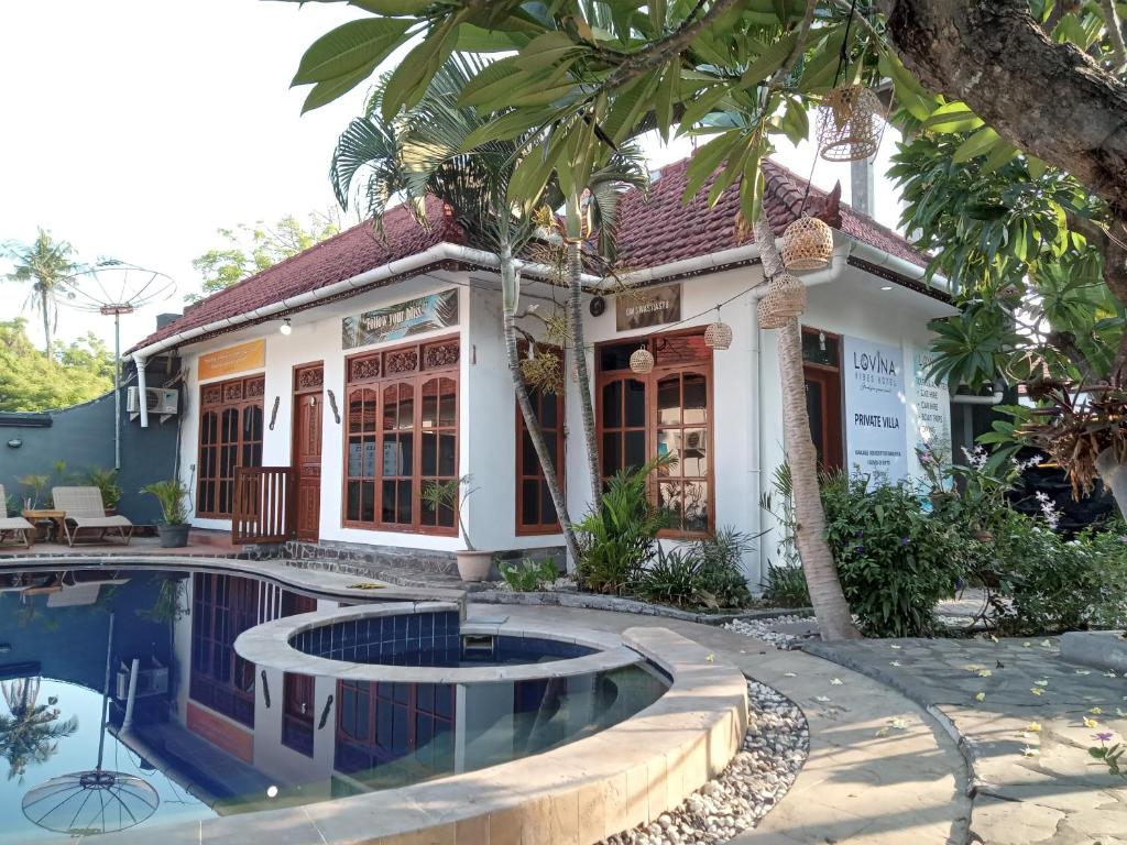 a house with a swimming pool in front of it at Lovina Vibes Hotel in Balian