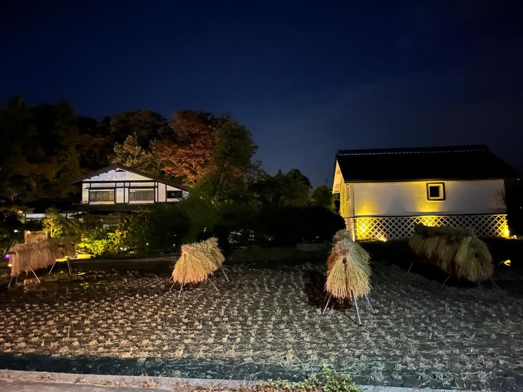 Una casa de noche con un montón de hierba en ゲストハウス かぶろの庭, en Matsukawa