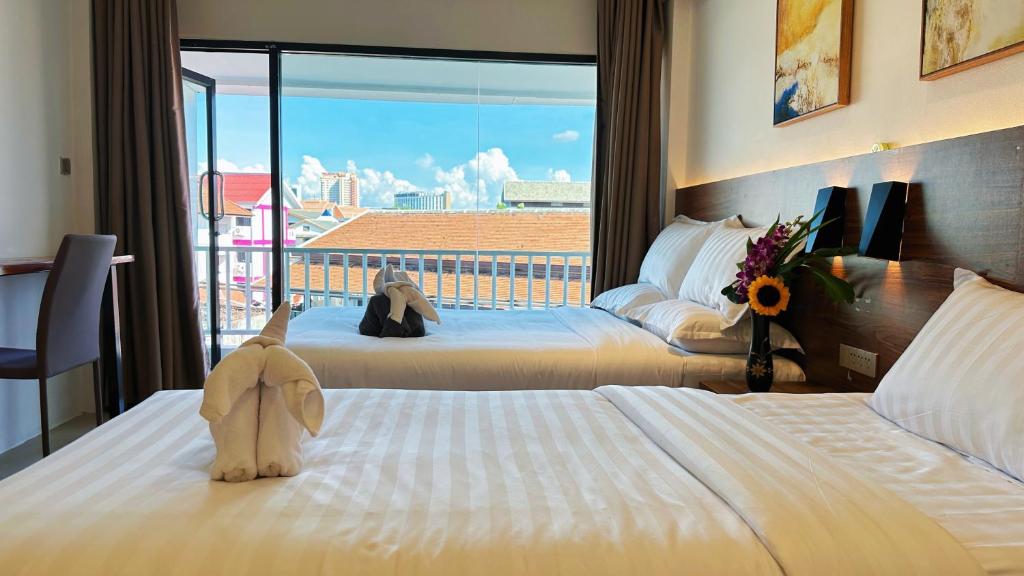 a hotel room with two beds with a stuffed animal on the bed at Key酒店@古城中心店 in Chiang Mai